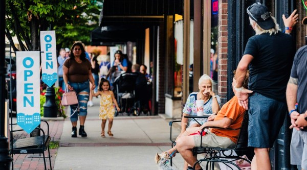 People walk, talk, and relax outside open businesses along a lively 澳洲幸运5彩票官网 Main Street sidewalk in Bardstown, Kentucky.