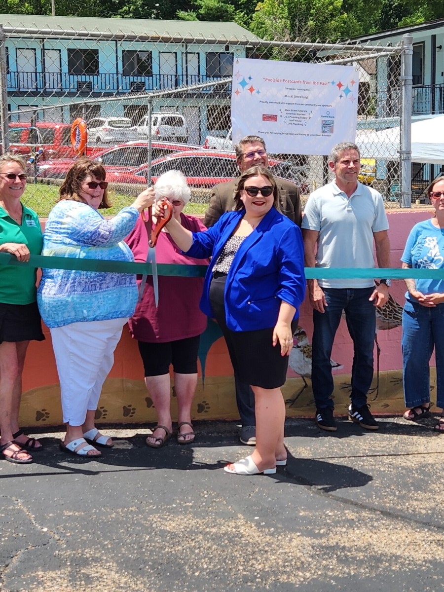 People cutting a ribbon outside a construction lot