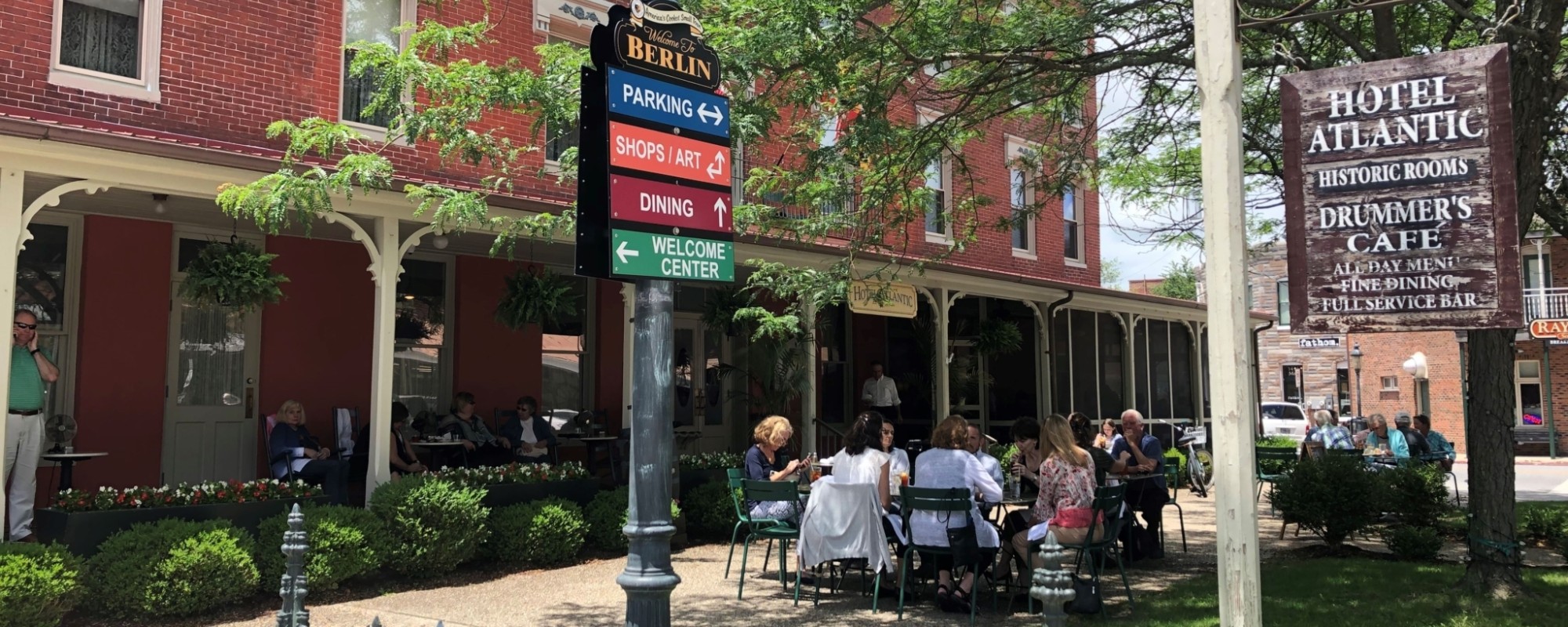 The historic Hotel Atlantic in Berlin, Maryland. A red brick building with a patio and outdoor dining.