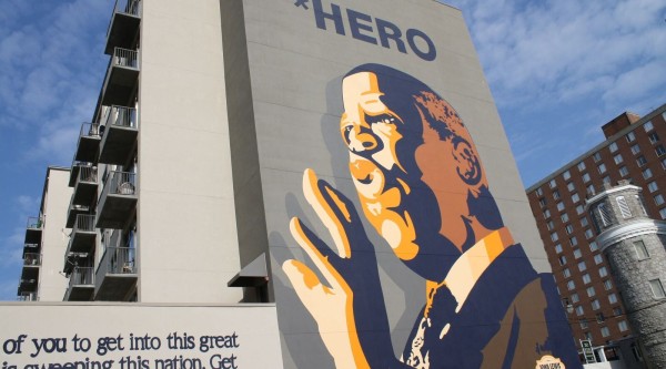 A large mural featuring John Lewis giving a speech