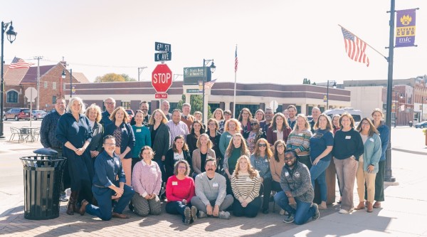 A large group of people posing on the sidewalk in Nevada, Iowa