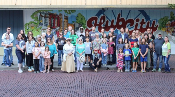 A large group of people in front of a mural celebrating Centralia's history