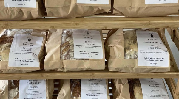 Packages of freshly baked bread on wooden shelves