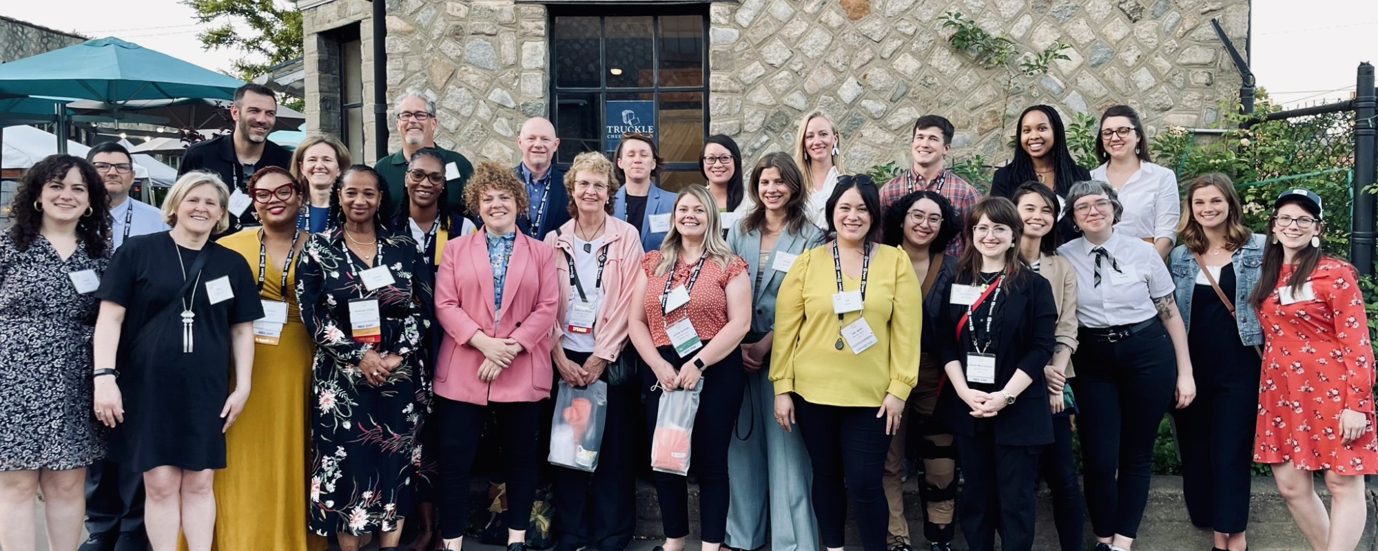 Large group of people pose for a photo in a courtyard.