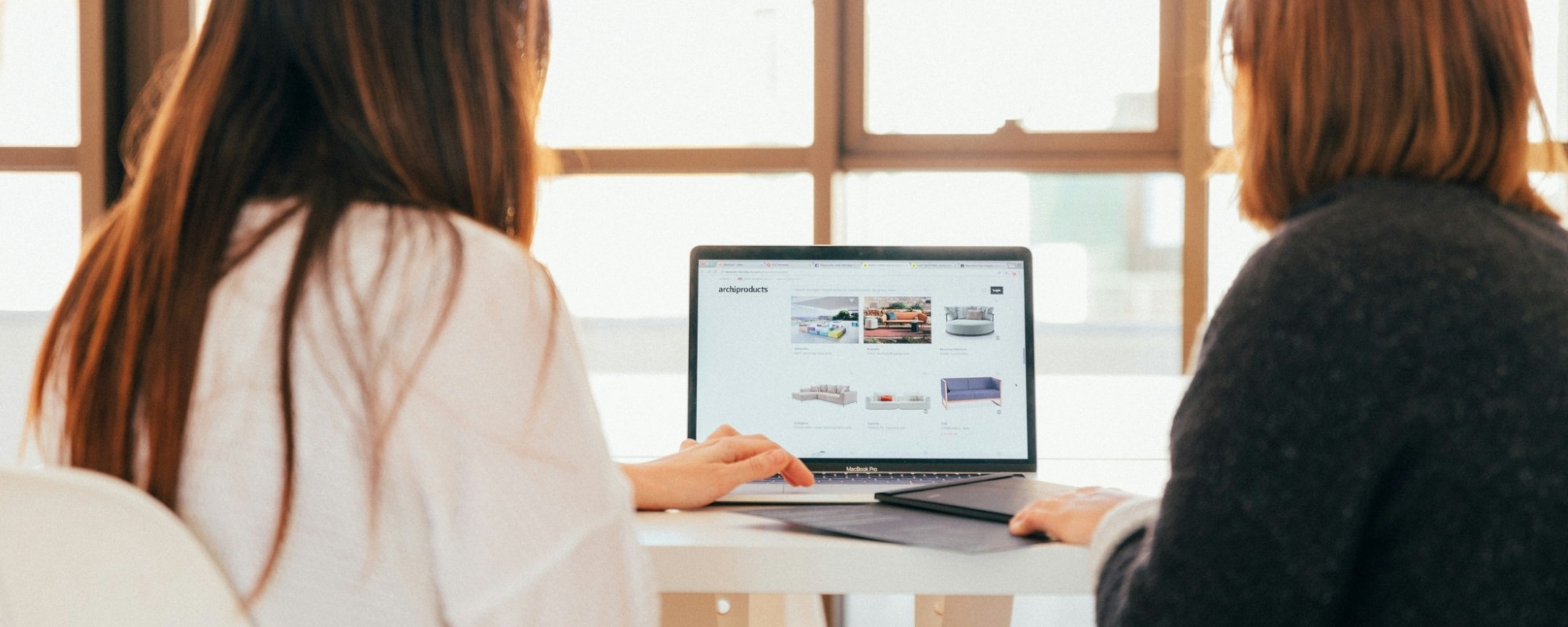 Two women looking at a website on a laptop