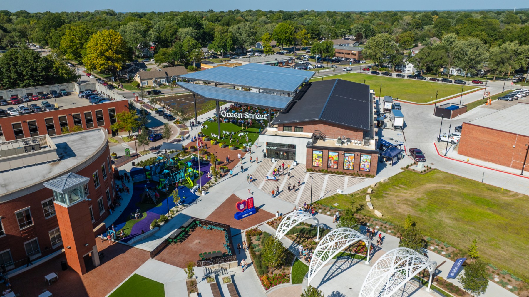 Large community complex with outdoor spaces, play spaces, art, and a farmers' market pavillion.