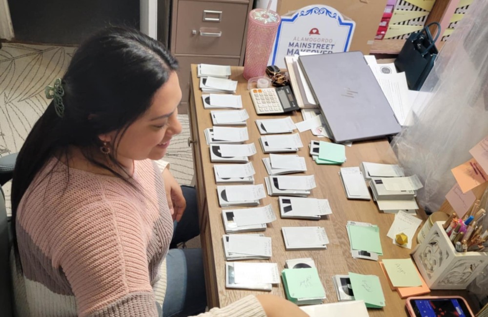 Woman organizing placards on large table.