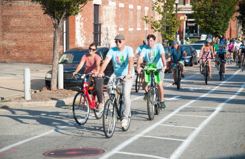 A large group of cyclists traveling down a bike lane.