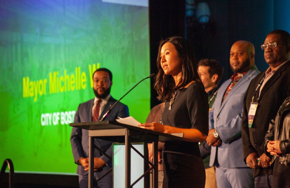 A woman speaks from a podium.