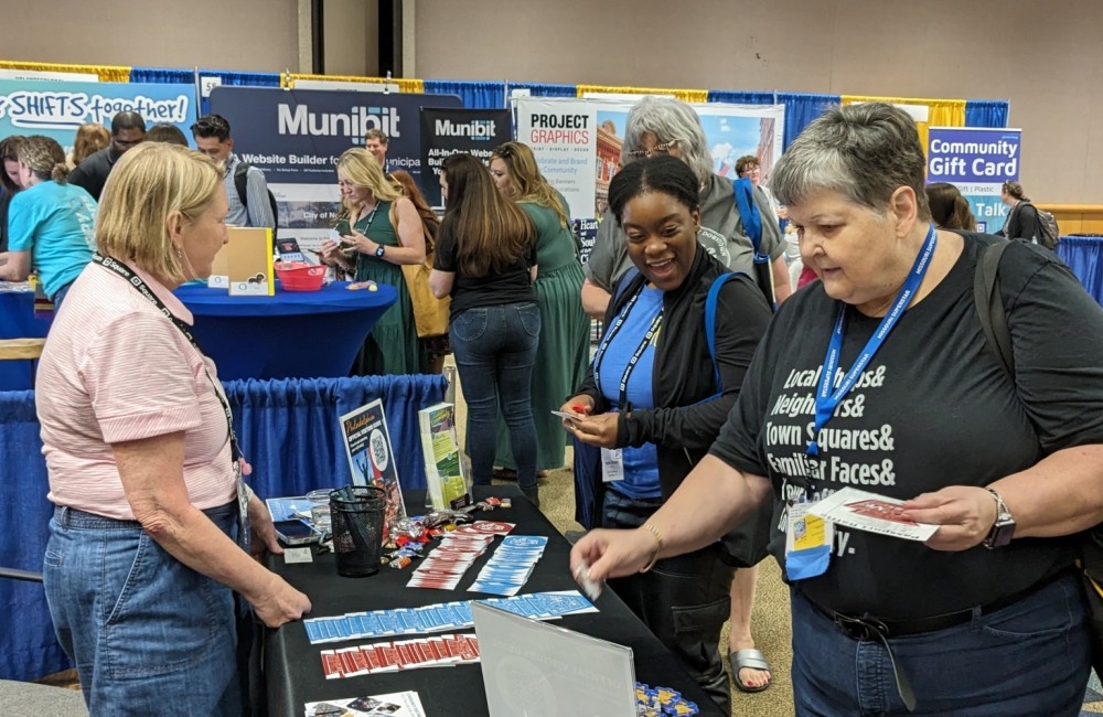 Two women visit a vendor booth.