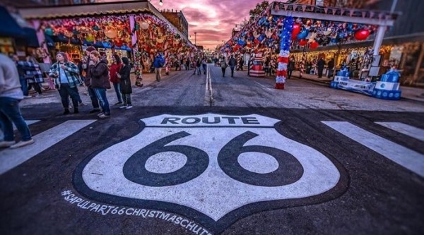Large route 66 sign street art on the pavement outside a bustling street market