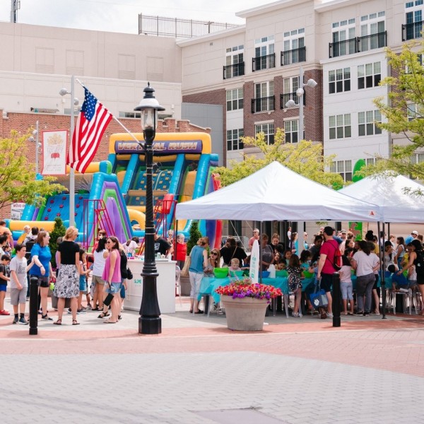 People gather and vendor booths are set-up in a plaza for spring bazaar event.