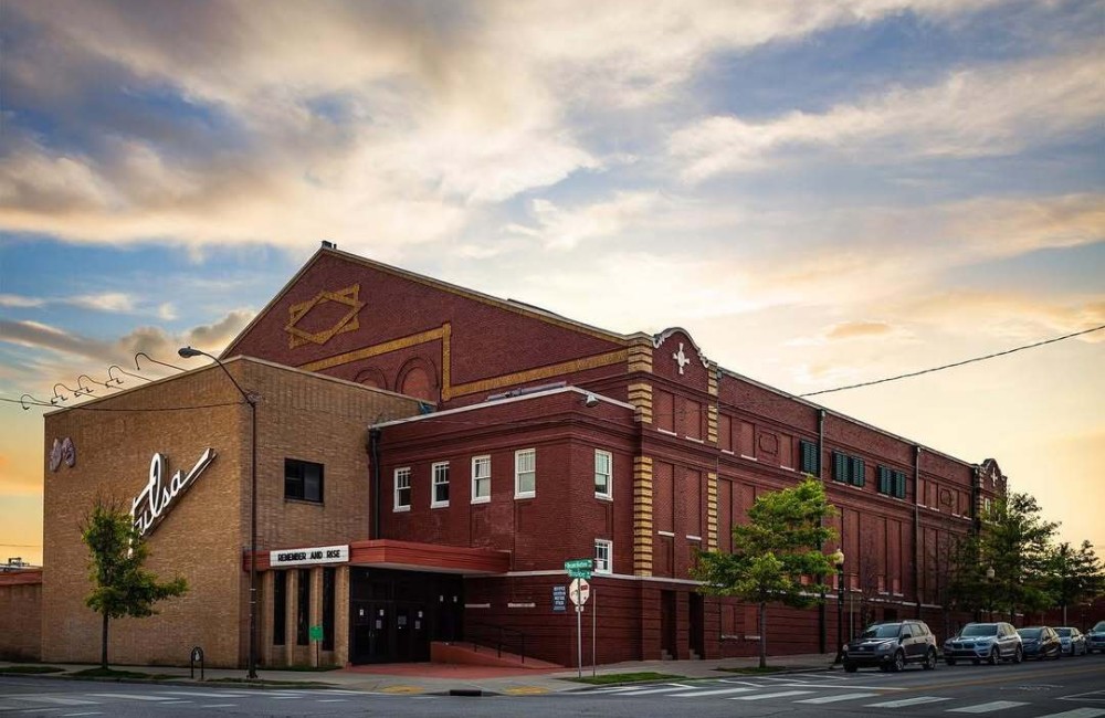 Large, two-story brick building on a tree-lined street.