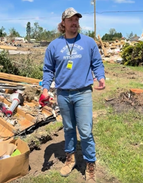 Joshua Ravenscraft wearing a Kentucky Strong sweater while helping with flood clean-up
