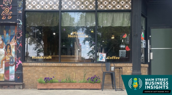 Image of a storefront. On the window is signage that reads "Plena Mercancía."