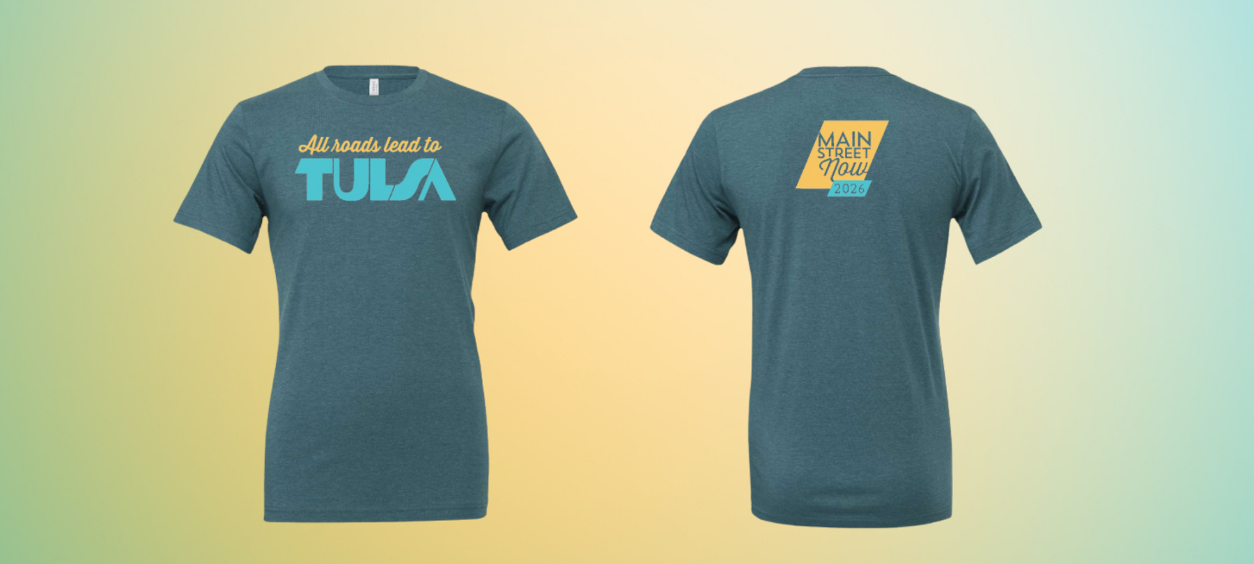 Two deep heather teal t-shirts on a yellow and green gradient background; the shirt on the left features a design reading "All roads lead to Tulsa" and the shirt on the right features the Main Street Now 2026 logo.