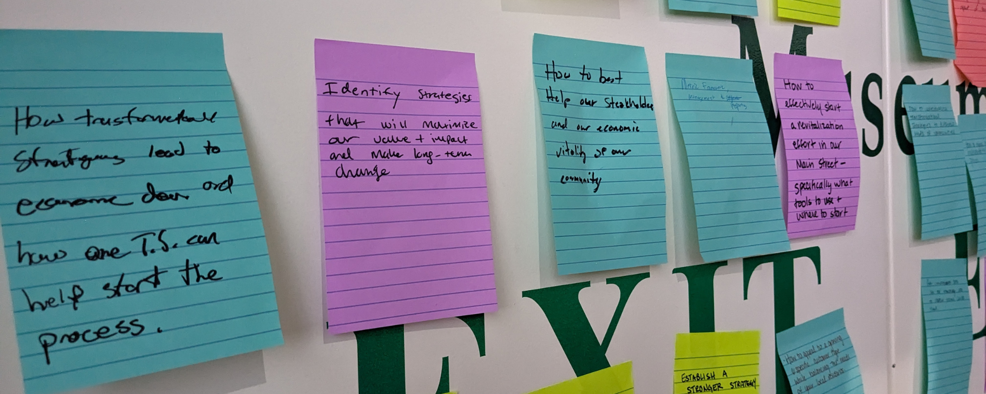 Sticky notes on a wall with reflections from participants in the 2023 Community Transformation Workshop