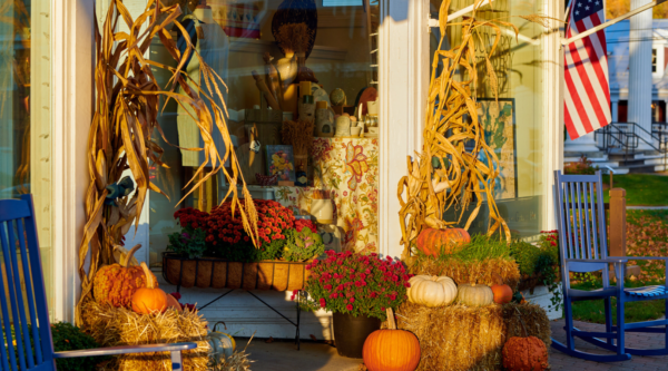 Storefront decorated for fall with pumpkins and straw