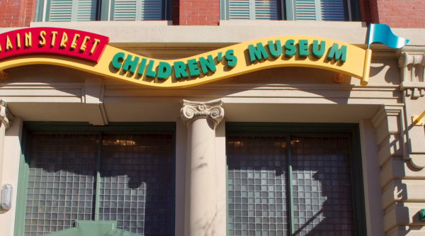 Facade of the Children's Museum featuring a colorful sign with a flag