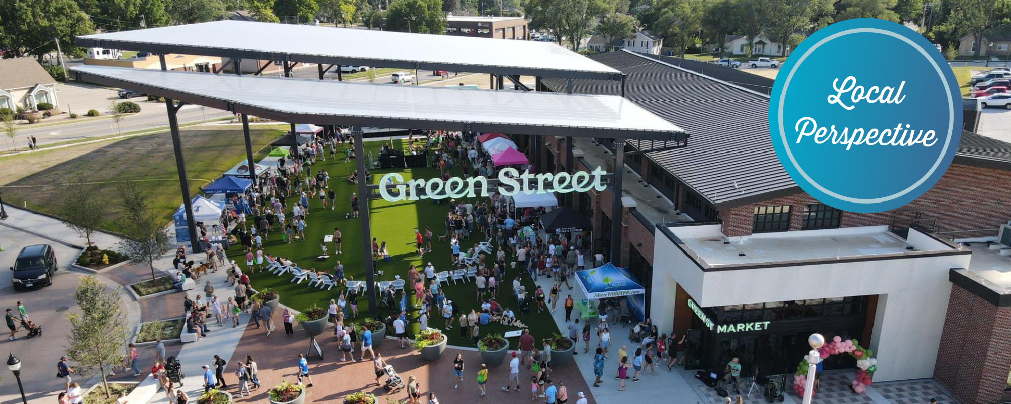 A large crowd of people exploring the farmers market at green street